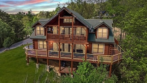 A log cabin with a balcony, multiple windows, and a porch. - A View To A Dream 4 Bedroom Home (Sevierville)