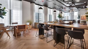 A modern office space with a long wooden table, multiple chairs, and a bar area. - 501 First Luxury Corner Studio Rooftop Pool & GYM 1101A (Miami)