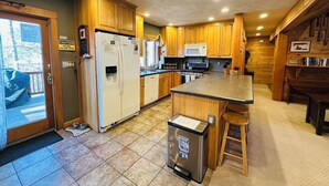 A kitchen with wooden cabinets, a refrigerator, a microwave, and a sink. - Soothing 3-bedroom house in quaint Conway perfect for relaxing stays (Conway)