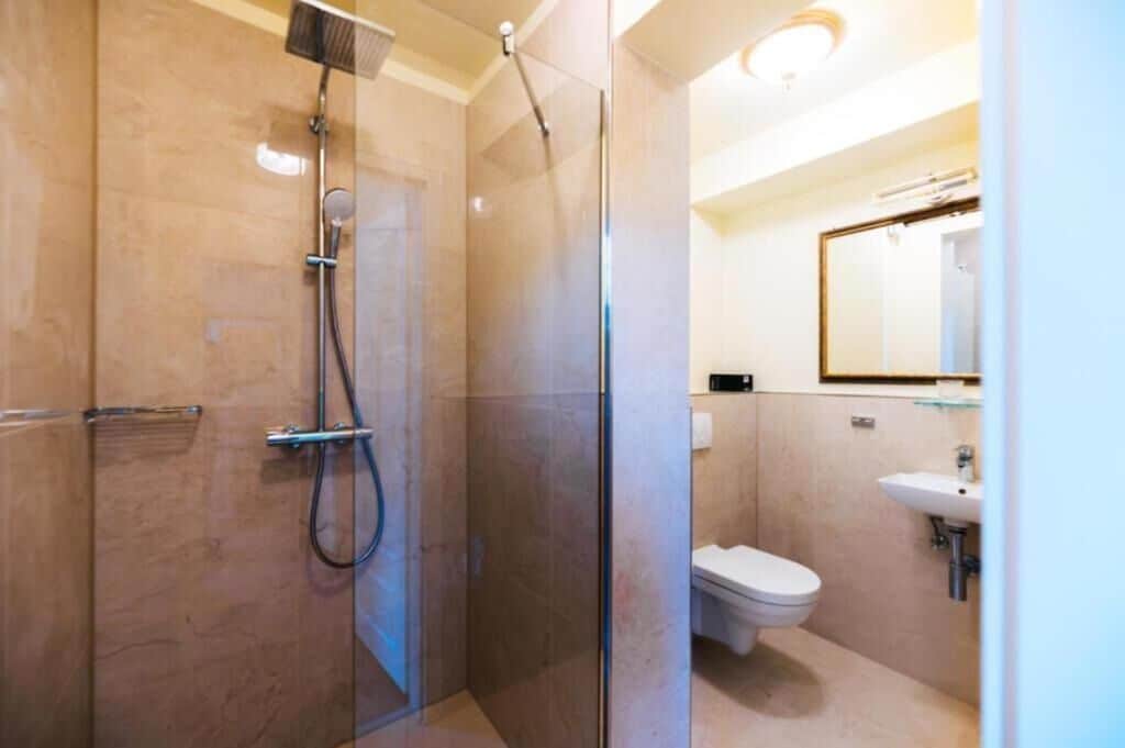 Une salle de bain moderne avec une douche à parois de verre, des toilettes et un lavabo.