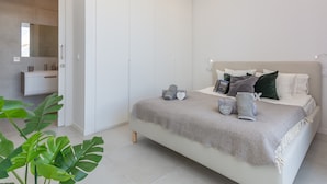 Ein modernes Schlafzimmer mit Bett, Nachttischen und einem Kleiderschrank.