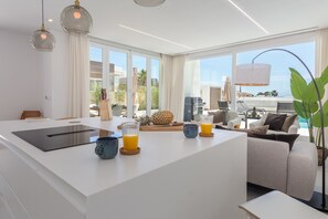 A modern kitchen with a central island, large windows, and a view of the outdoors. - Modern Villa Retreat in Mijas Costa (Mijas)