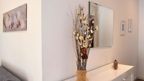 A modern interior with a white console table, a vase with dried branches and flowers, and a mirror above. - Francy's House, just minutes from the Vatican (Roma)