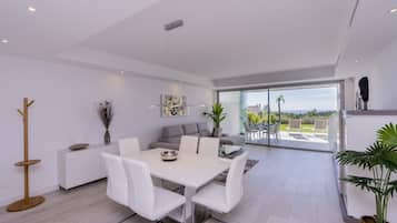 Un interior moderno con comedor, sofá y vistas al exterior.