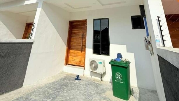 Una moderna casa a due piani con tetto piano, ampie finestre e un balcone.