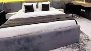 Una camera da letto moderna con un letto grande, comodini, uno specchio e una scrivania integrata.