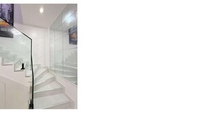 Una moderna scala con ringhiere in vetro e un design minimalista.