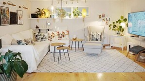 Uma sala de estar moderna com um sofá, poltronas, uma mesa de centro e uma televisão.