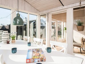 A bright, open-plan living space with a large table, chairs, a hanging light fixture, and a puzzle on the table. - 6 Person Holiday Home in Ronde (Ronde)