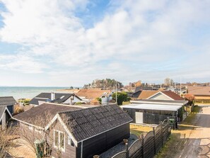 A coastal residential area with houses, a beach, and a clear sky. - 6 Person Holiday Home in Ronde (Ronde)