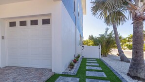 Een modern huis met een witte garage, een verharde oprit en een verzorgd gazon met stenen paden.