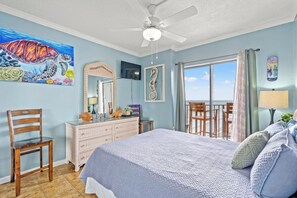 A bedroom with a bed, a dresser, a chair, a ceiling fan, and a view of the ocean through a sliding door. - Experience Breathtaking Ocean Views (Myrtle Beach)