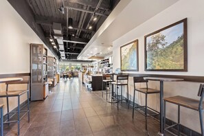 A modern cafe with a long counter, bar seating, and a visible kitchen area. - Direct Oceanfront Relaxation Starts Here (Myrtle Beach)
