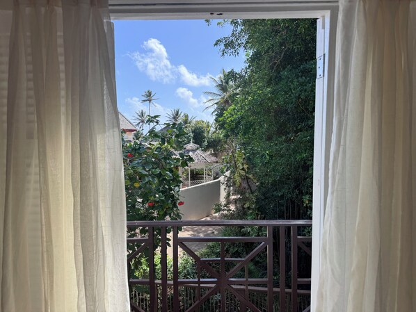 A balcony with a view of a garden and a gazebo.