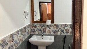 A bathroom with a white sink, a mirror, and a shower.