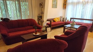A living room with red sofas, a coffee table, and a small table with a plant.