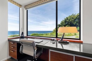 Ein moderner Schreibtisch mit Meerblick, eine Lampe und ein Stuhl.