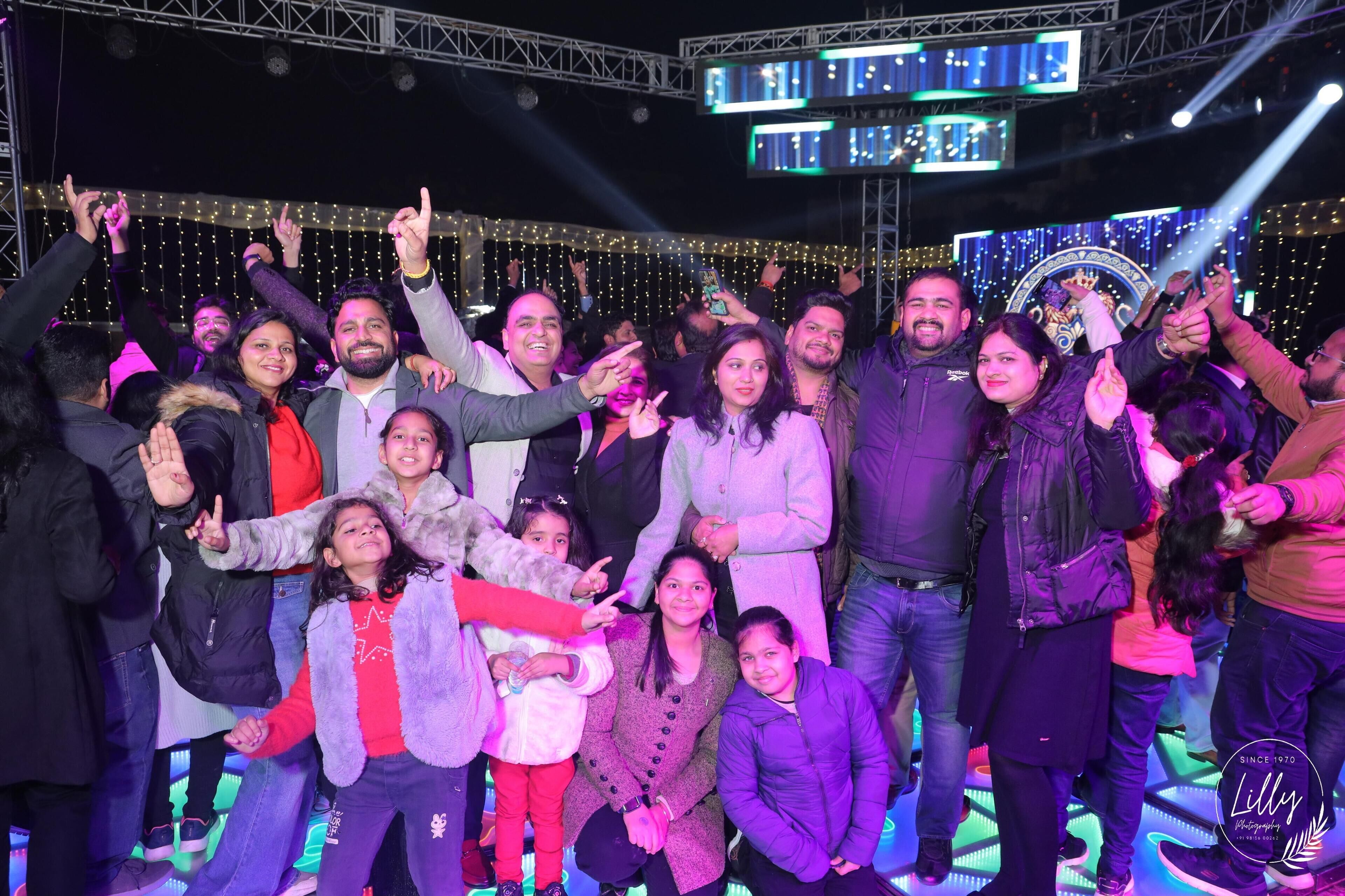 Un grupo de personas posando en un escenario con un fondo de luces y un logotipo.