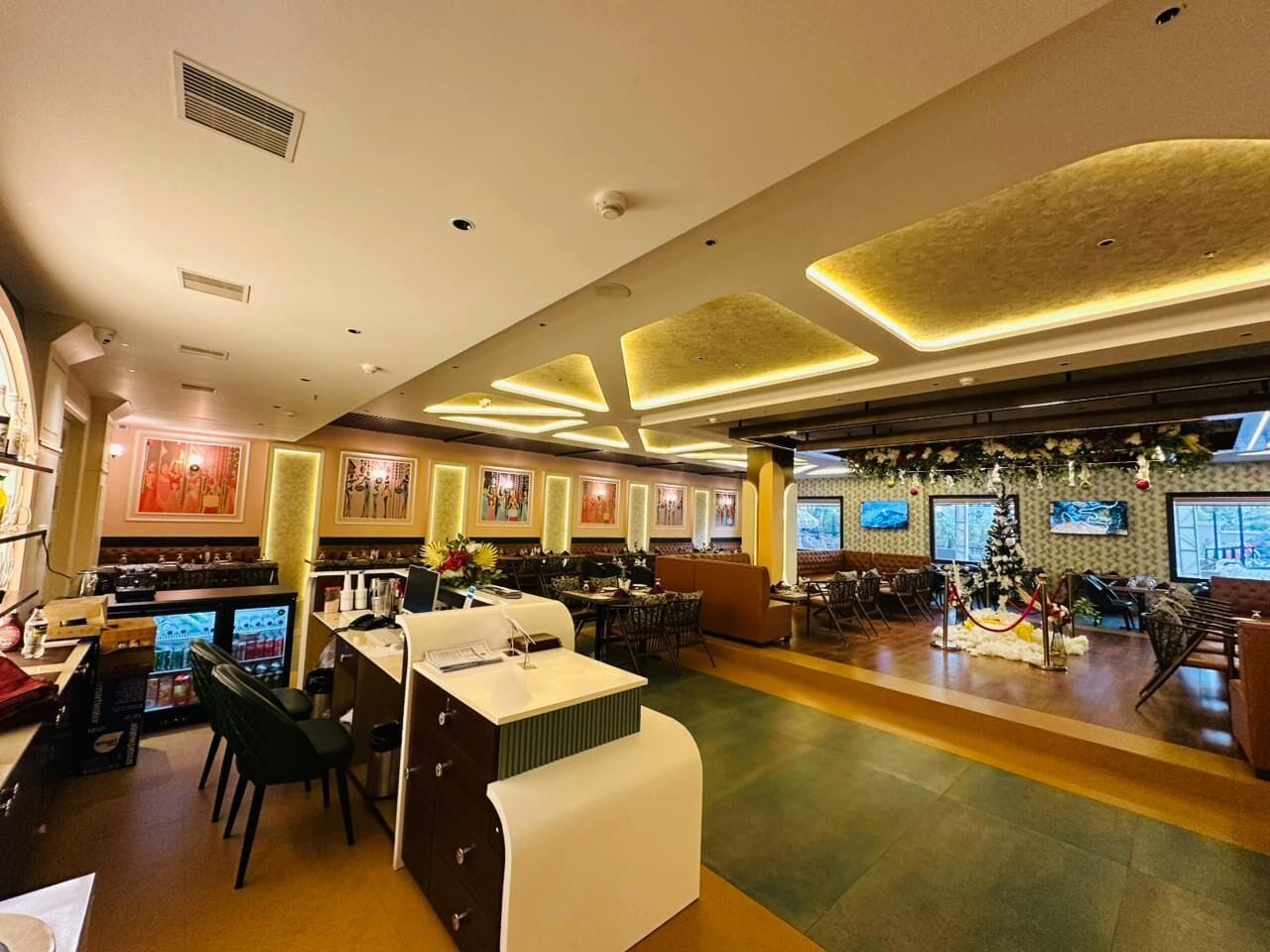 Un restaurante espacioso con barra, mesas y una decoración de árbol de Navidad.