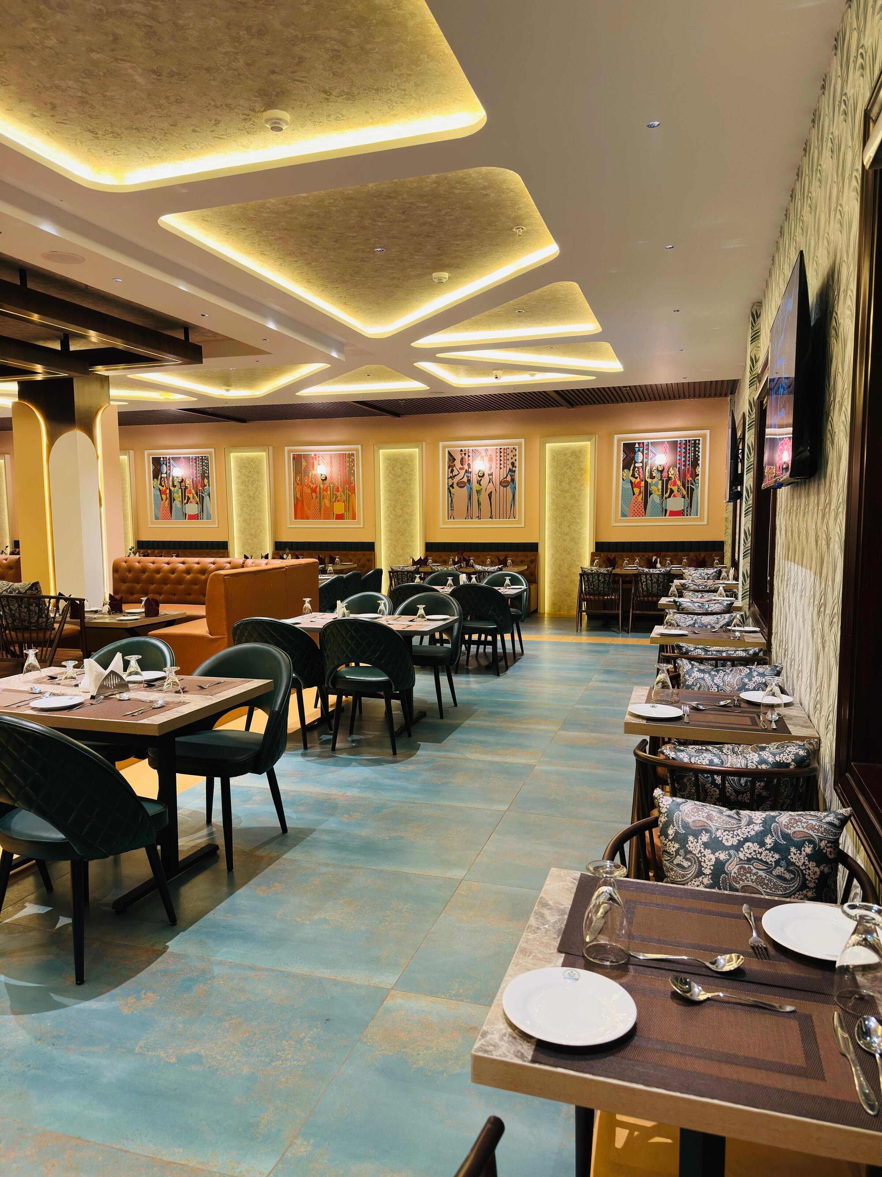 A restaurant with a long counter, multiple tables, and chairs.