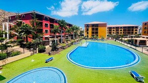 A hotel with two swimming pools, a red building, and a yellow building. - Sunny Apartment for 4 in Vera (Arona)