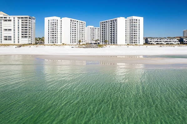 A beachfront hotel with multiple high-rise buildings, clear shallow waters, and a sandy beach. - Beautiful ST 3054 w/Private Enclosed Balcony (Destin)