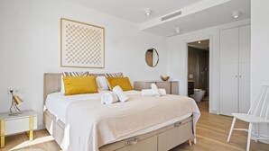 Ein modernes Schlafzimmer mit einem Bett, Nachttischen, einem Spiegel und einem Kleiderschrank.