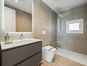 A modern bathroom with a glass-enclosed shower, a white sink, and a dark-toned vanity. - Chic Casares Penthouse With Solarium (Casares)