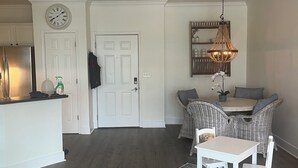 A modern kitchen with white cabinetry, a stainless steel refrigerator, and a clock on the wall. - Delightful 2-bedroom renovated condo with AC in charming Charleston (Charleston)