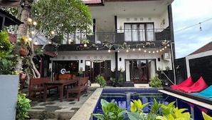 A two-story house with a balcony, outdoor seating, and a swimming pool. - Q-Star Uluwatu (Ungasan)
