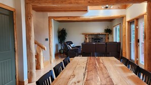 Una mesa de comedor de madera con sillas, una chimenea y una escalera.