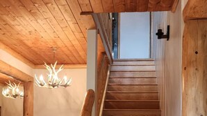 Una escalera de madera con barandilla que lleva a un piso superior.