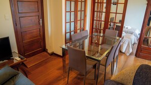 A dining area with a glass table and chairs, a wooden door, and a sofa. - Penthouse with two terraces at the Old City [502]. (Montevideo)