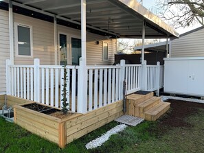 A house with a covered porch, a white fence, and raised garden beds. - Mobile home 6 persons in campsite with swimming pools in Biscarrosse Lac (Biscarrosse)