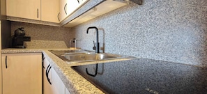 A kitchen with granite countertops, a stainless steel sink, and a coffee maker. - Seafront Studio w/Stunning Sea Views (Blankenberge)