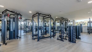 A gym with various weightlifting equipment, mirrors, and a wooden floor. - Apartment Stay at Alcazaba Lagoon (Casares)