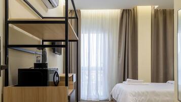 Escritorio, cortinas blackout y tabla de planchar con plancha