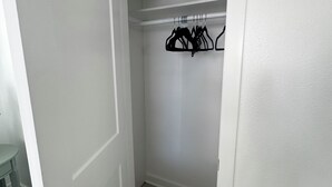 Eine geschlossene Tür zu einem Schrank mit Kleiderstange und einem kleinen Tisch.