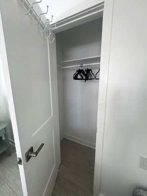 Eine geschlossene Tür zu einem Schrank mit Kleiderstange und einem kleinen Tisch.