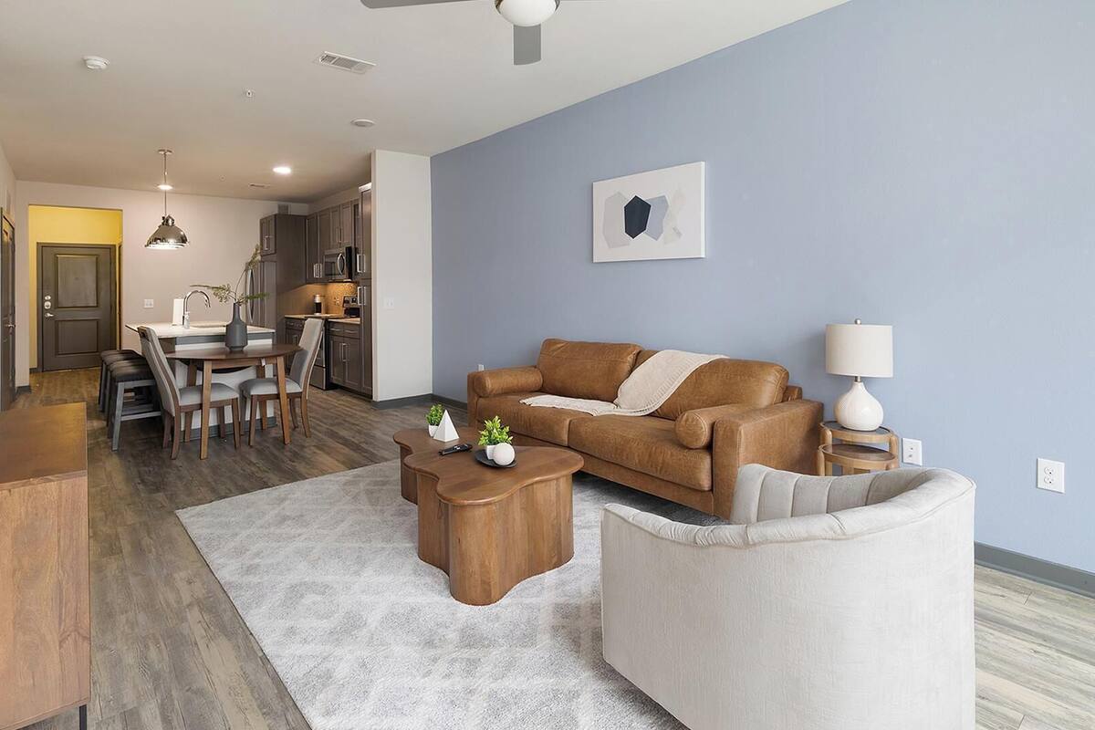 Un salon moderne comprenant un canapé, une table basse et un coin repas avec des chaises et une table.