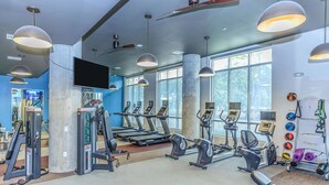 A gym with treadmills, elliptical machines, and free weights. - Landing Amazing 1bd, Courtyard, Game Room (Houston)