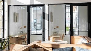 A modern interior with a large window, a round table, and a seating area with a sofa and chairs. - Landing Apartments - Southeast Austin (Austin)