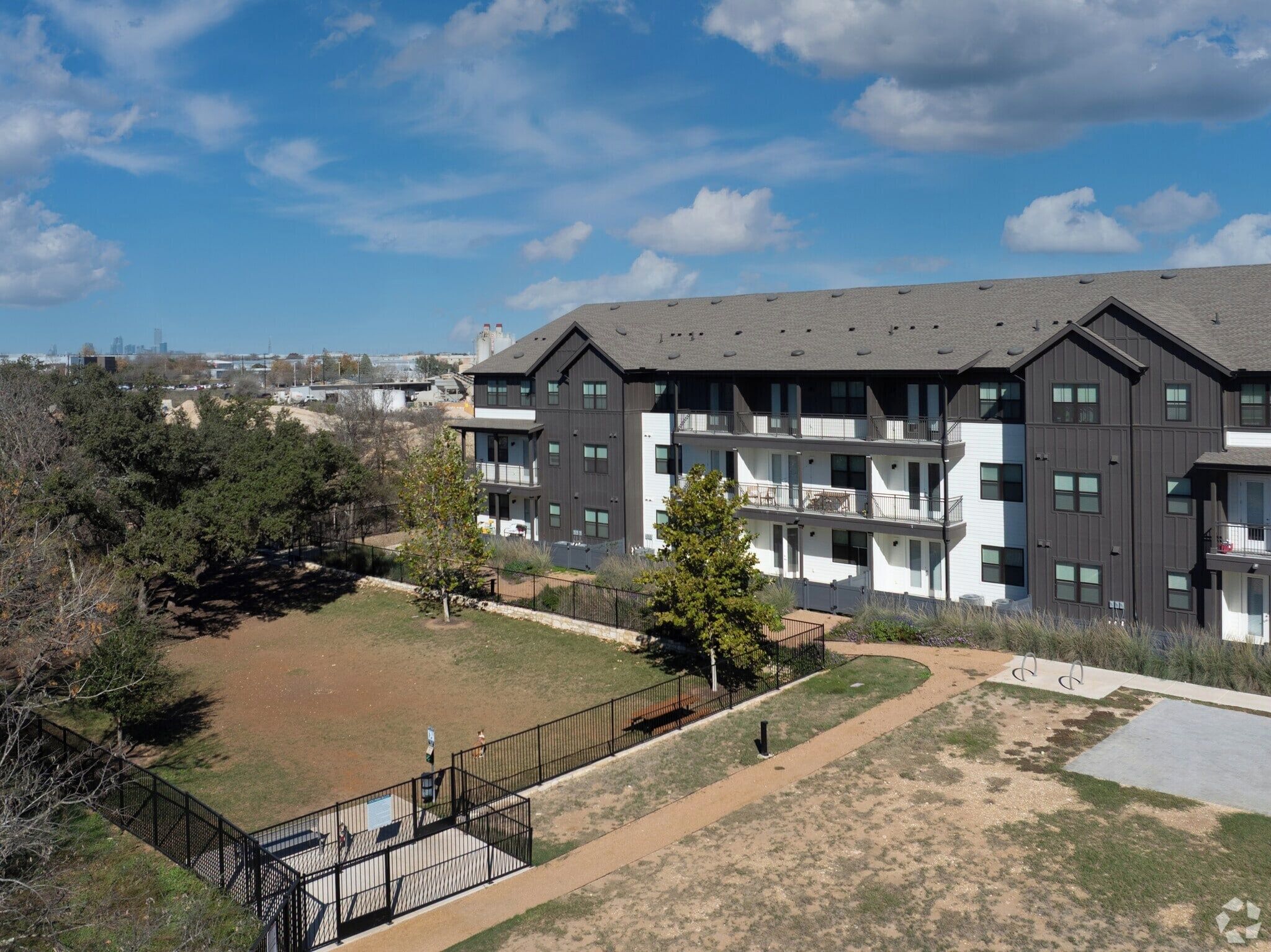 Un immeuble à plusieurs étages doté de balcons, d’une courClose et d’un ciel dégagé.