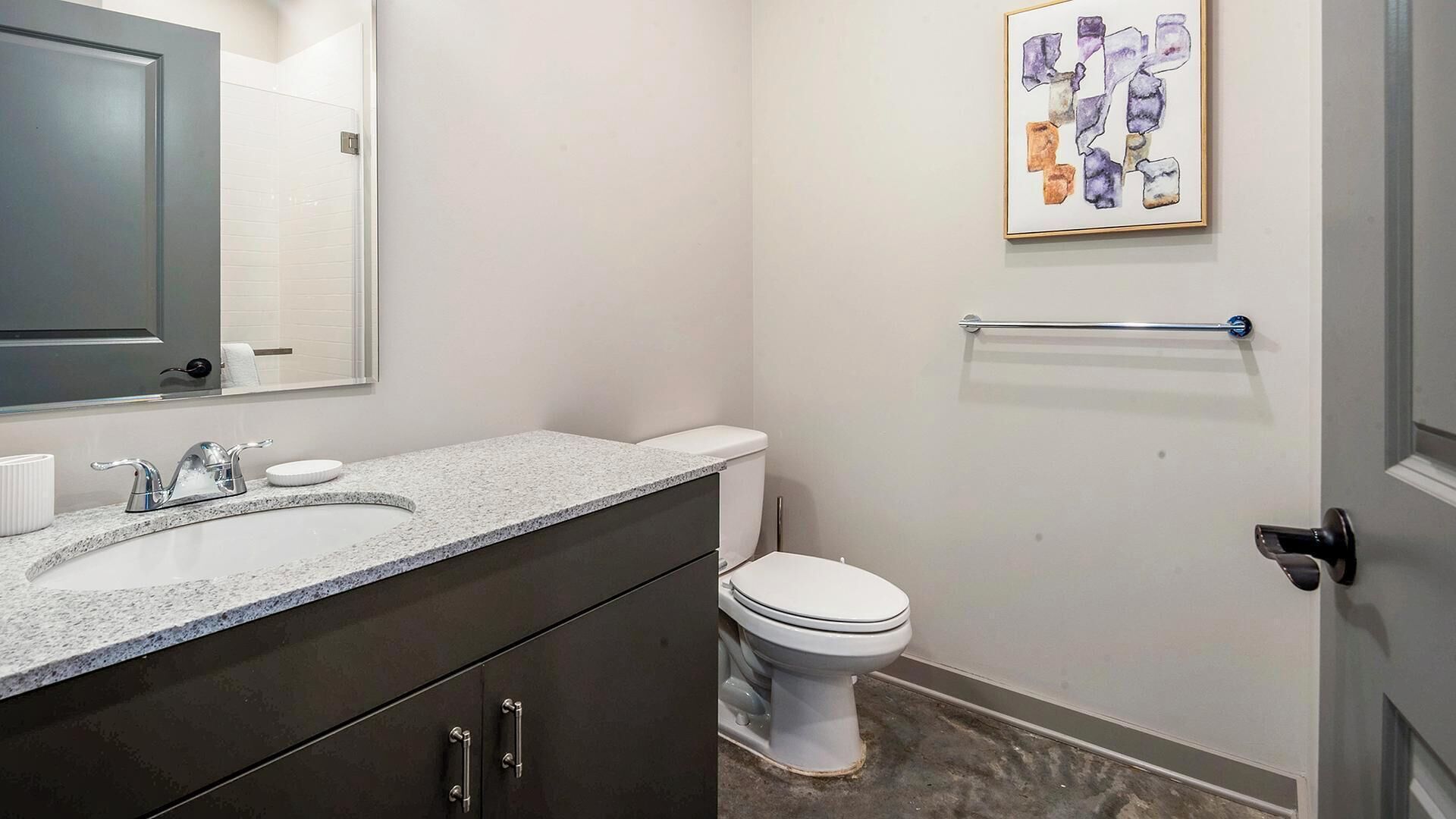 A bathroom with a sink, toilet, and a towel rack.