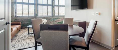 A modern living room with a sofa, a round table, and chairs.