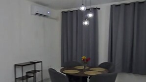 A dining area with a round table, chairs, and a small shelf. - Residencia Puerto Morelos (Puerto Morelos)