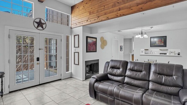 Un salón amplio con sofá de cuero, chimenea y comedor.