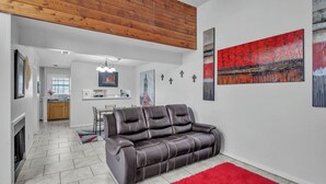 Una sala de estar moderna con un sofá de cuero, una alfombra roja y un cuadro en la pared.