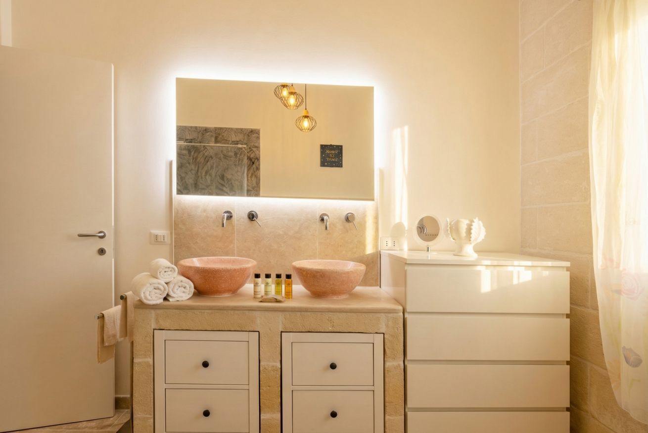 Une salle de bain avec un double lavabo, un miroir et un meuble-lavabo avec des tiroirs.