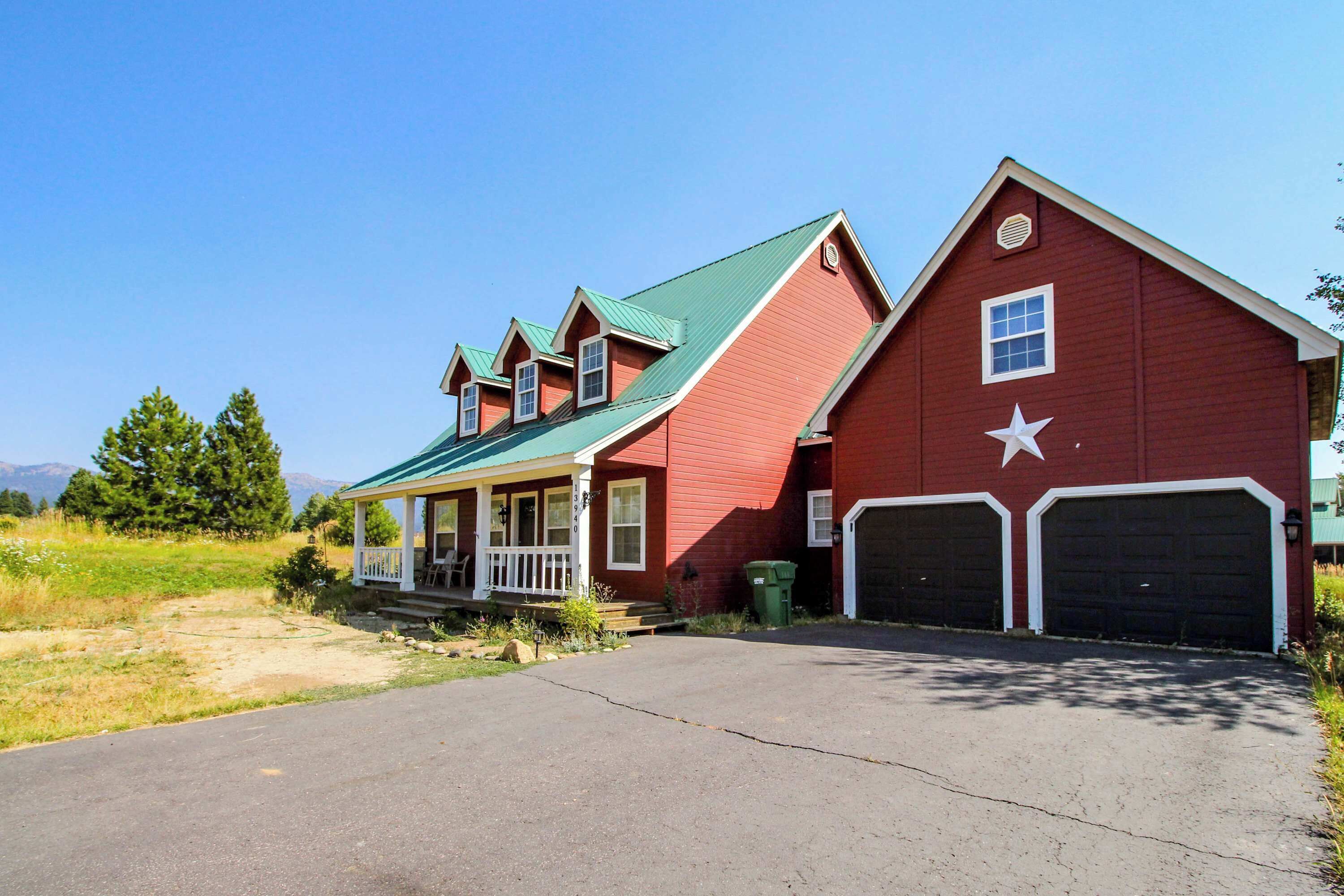 A red barn-style house with a porch and two garage doors.